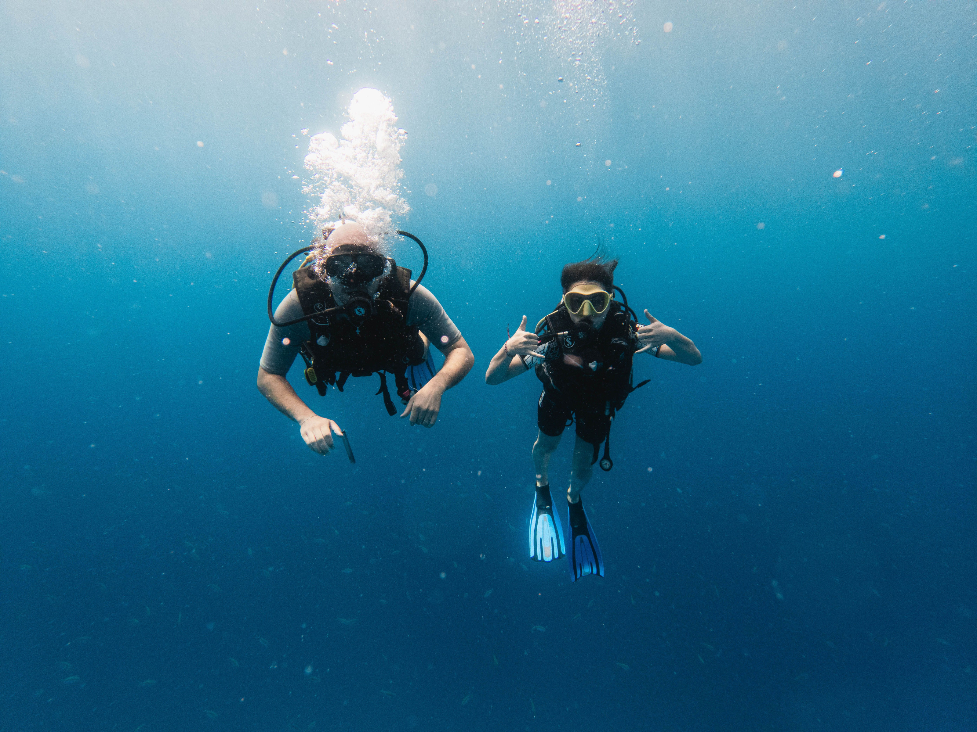 Two divers glide through clear turquoise water off the Zanzibar archipelago coast.