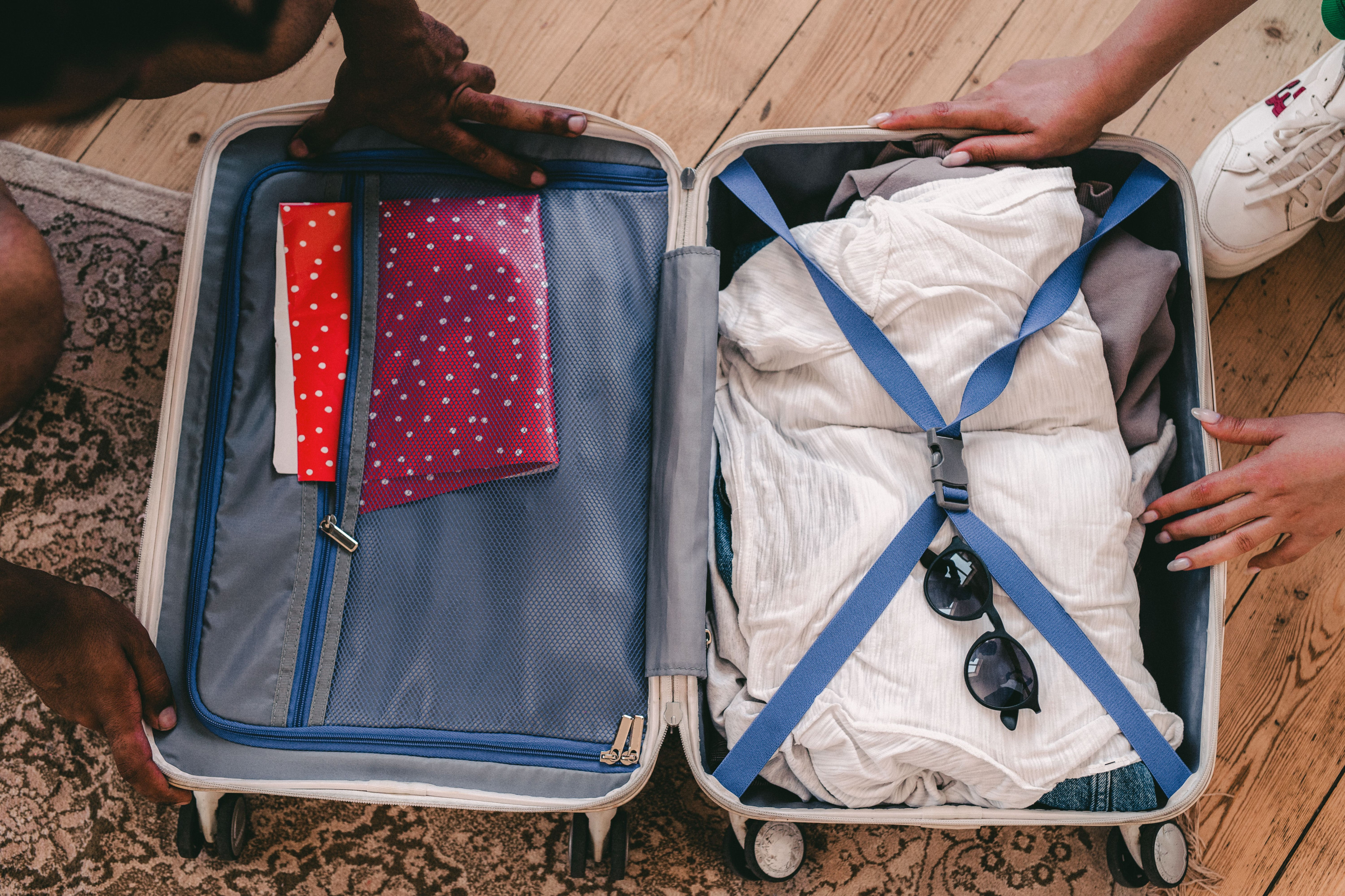 A neatly packed open travel bag with folded clothing laid out and ready for a safari trip.